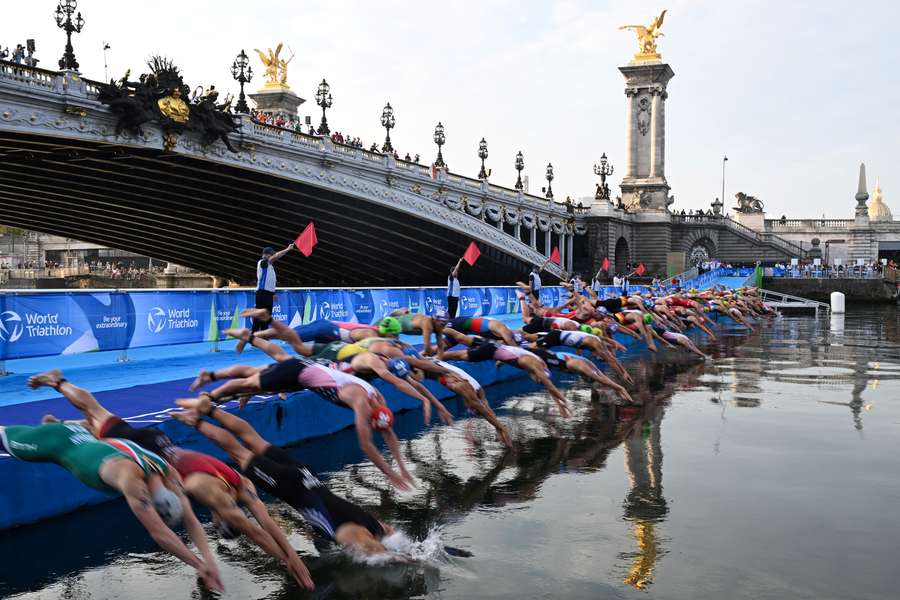 Triathlon athletes dive in the Seine river during the men's 2023 World Triathlon Olympic Games Test Event