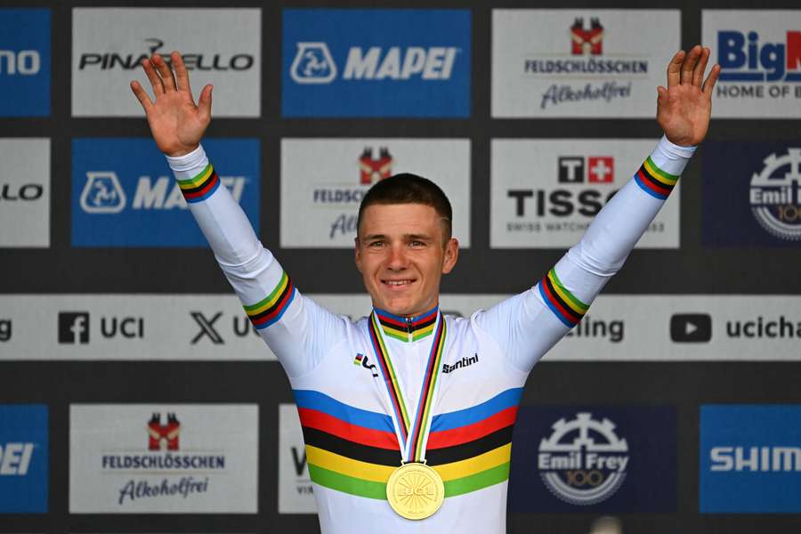 Remco Evenepoel poses on the podium