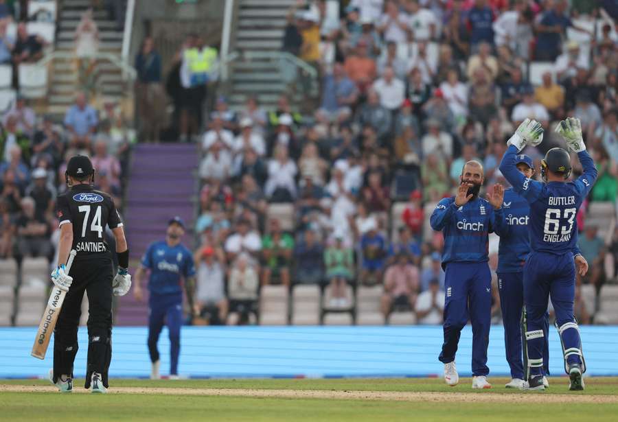 New Zealand's Mitchell Santner (L) leaves the field as England's Moeen Ali (3R) celebrates taking his wicket