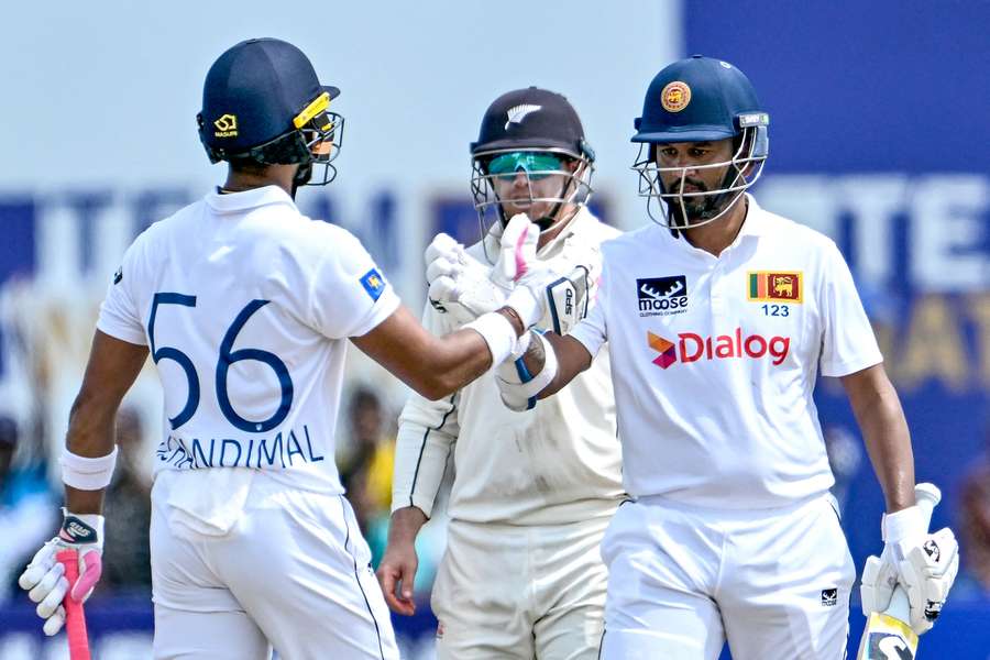 Dimuth Karunaratne (right) celebrates with Dinesh Chandimal after scoring a half-century