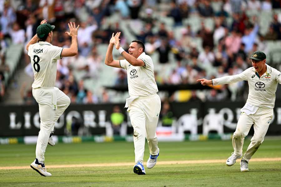 Australian bowler Scott Boland (centre) celebrates with teammates Mitch Marsh and Marnus Labuschagne after dismissing Indian batsman Virat Kohli