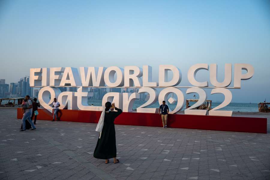 Visitors take photos with a FIFA World Cup sign in Doha