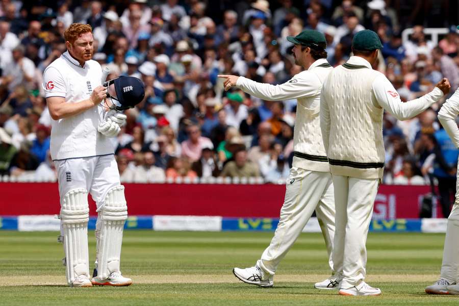 Australia's Travis Head (C) points as he talks with England's Jonny Bairstow whilst the await the successfully appeal for Bairstow's wicket for 10 runs