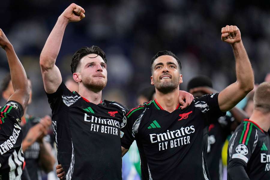Declan Rice (l) celebrates Arsenal's win in Madrid with Mikel Merino