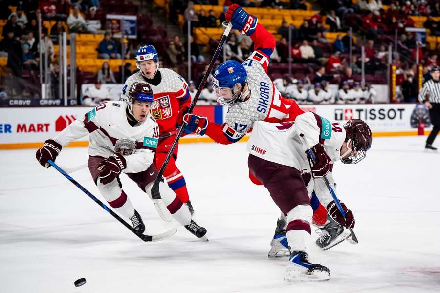 Petr Sikora padá v souboji s bránícím Lotyšem.