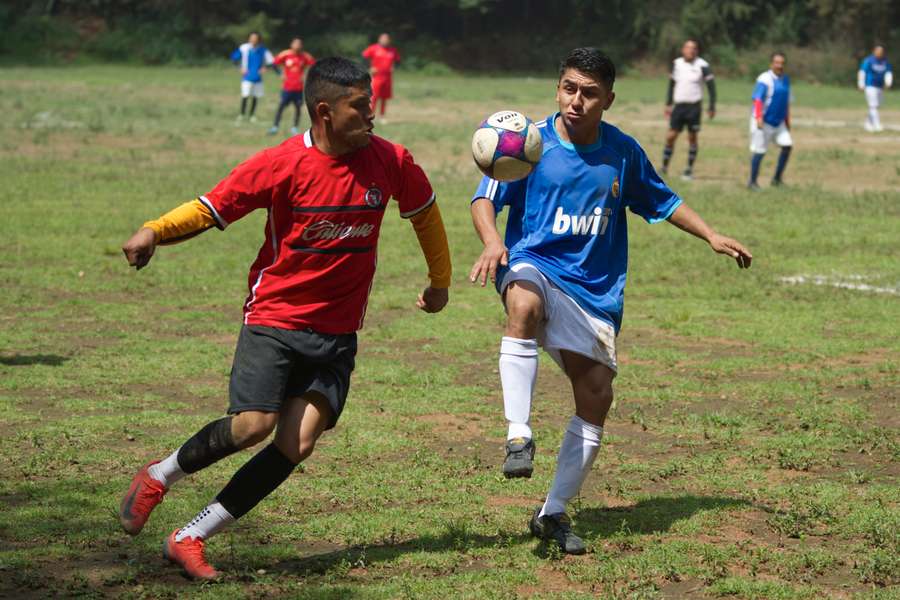 Dos jugadores de distintos equipos pugnan por la posesión del balón