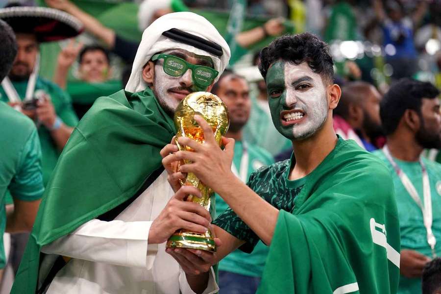 Kibice Arabii Saudyjskiej z repliką trofeum podczas MŚ w Katarze