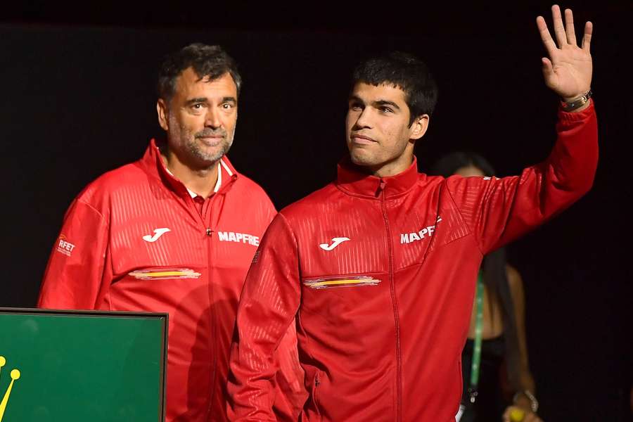 Spanish player Carlos Alcaraz (R) waves next to Spain's Davis Cup captain Sergi Bruguera.