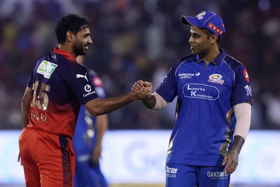 Mumbai Indians' Suryakumar Yadav shakes hands with Royal Challengers Bengaluru's Bhuvneshwar Kumar 