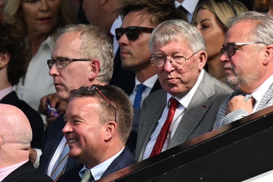 Former United manager Alex Ferguson (2R) takes his seat for the English Premier League football match between Manchester United and Fulham at Old Trafford