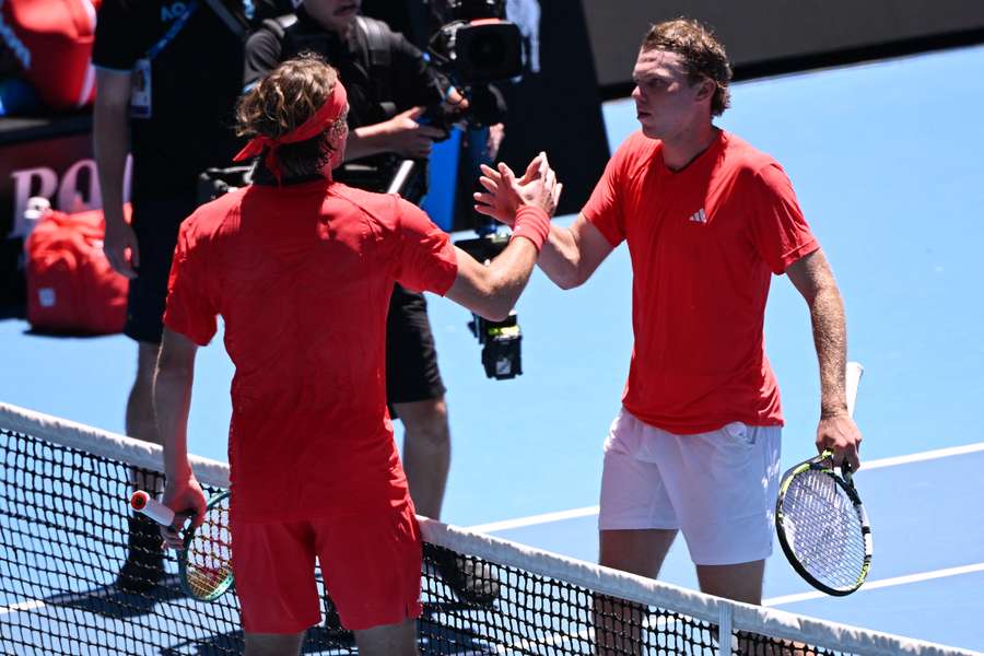 Alex Michelsen (d) es felicitado por Stefanos Tsitsipas tras su victoria
