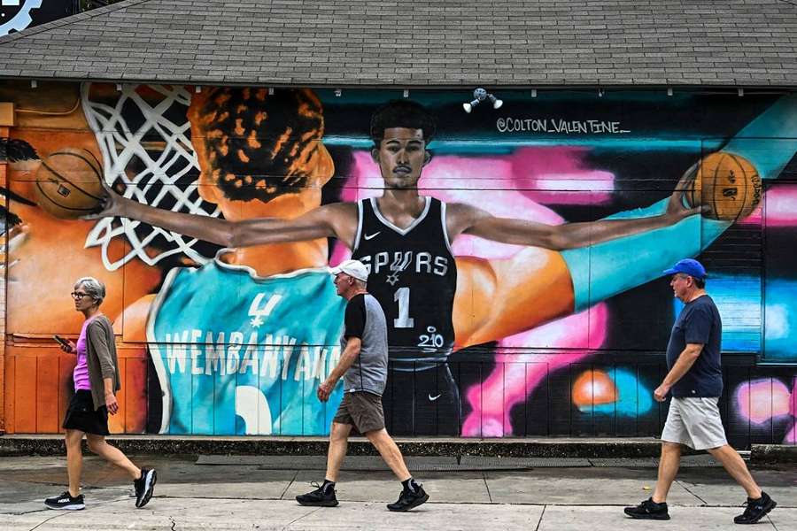 Des gens passent devant une peinture murale du français des San Antonio Spurs Des gens passent devant une peinture murale du français des San Antonio Spurs
