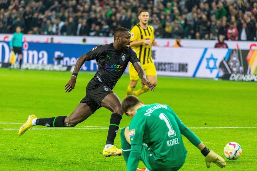 Marcus Thuram passeert doelman Gregor Kobel in de wedstrijd tussen Borussia Mönchengladbach en Borussia Dortmund van afgelopen zonder (4-2)