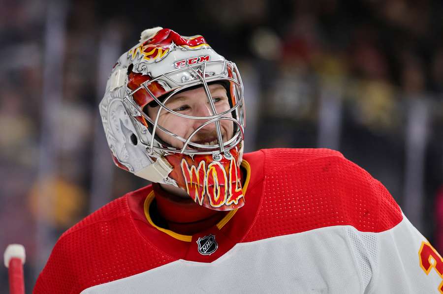 Calgary Flames goalie Dustin Wolf smiles during a stoppage in play (2023)