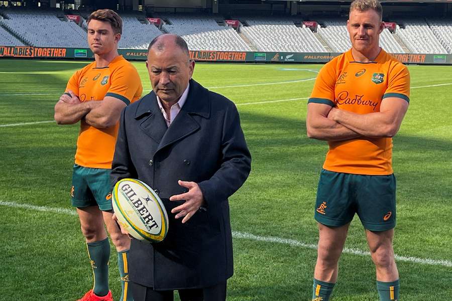 Eddie Jones posing with players at news conference in May