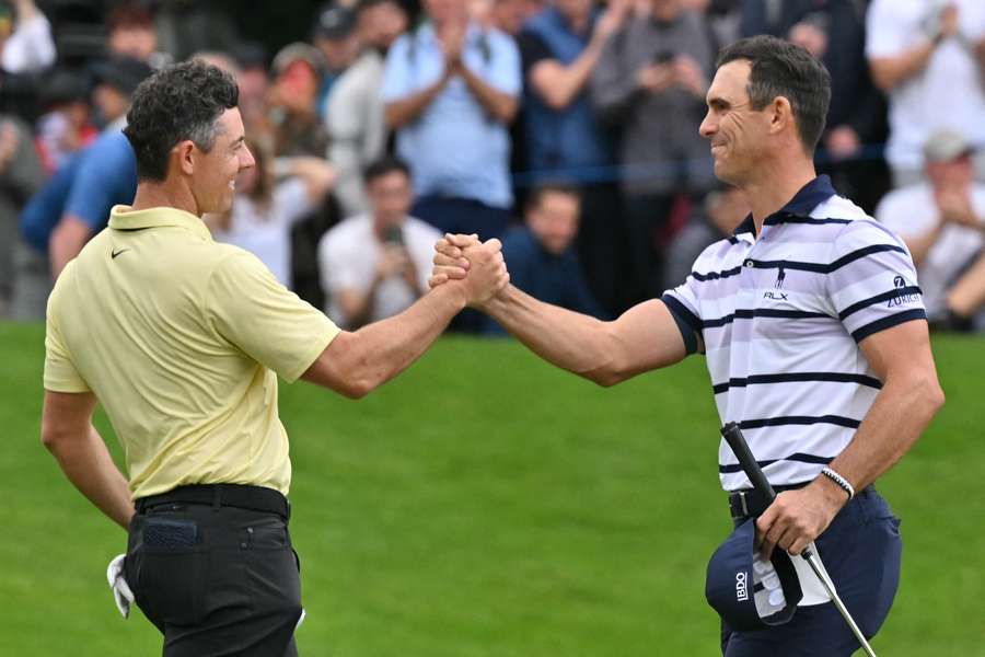 Billy Horschel shakes hands with Rory McIlroy after beating him on the 18th green