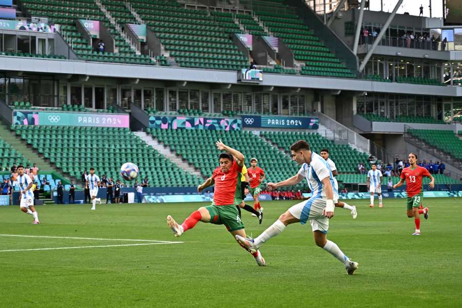 Argentina's forward #09 Julian Alvarez (R) challenges Morocco's midfielder #06 Benjamin Bouchouari after the match started again in an emptied stadium