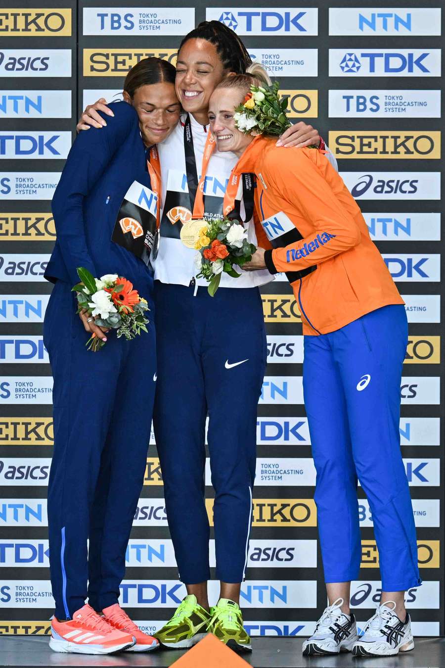 Katarina Johnson-Thompson smiles after receiving her medal alongside USA's Anna Hall and Netherlands' Anouk Vetter