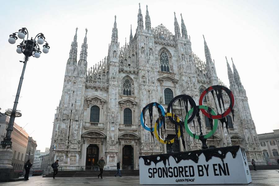 Environmental activists from Greenpeace unveil a large symbolic installation during a demonstration near the Duomo di Milano, as the Olympic torch arrives in Milan