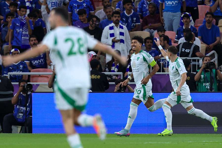 Ahli's Brazilian forward #10 Roberto Firmino celebrates with his teammates after scoring his team's first goal 