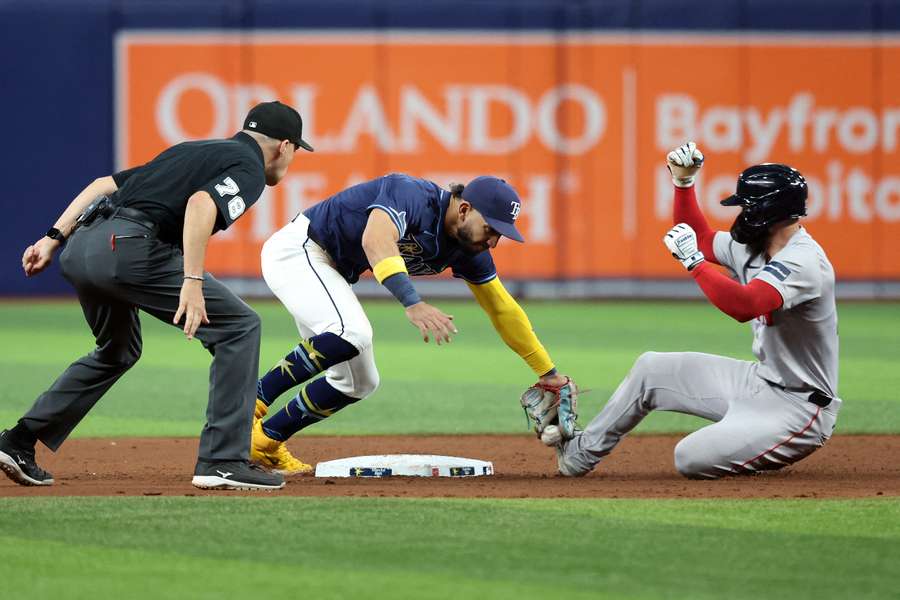 Tampa Bay Rays shortstop Jose Caballero drops the ball as Boston Red Sox catcher Connor Wong slides safe into second base during the ninth inning