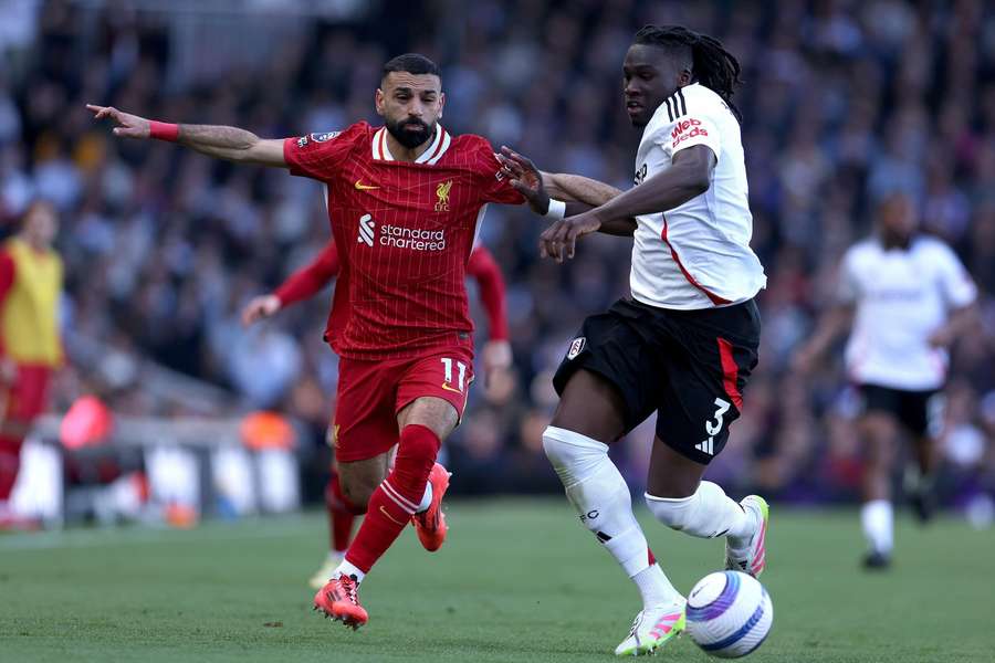 Liverpool's Mo Salah and Fulham's Calvin Basseychallenge for the ball during the Premier League match at Craven Cottage on April 6, 2025.