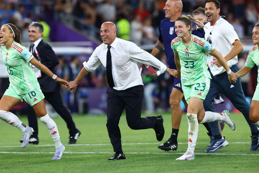 Italy coach Andrea Soncin running with Cecilia Salvai (left) and Eleonora Goldoni (right) after defeating Norway in EURO 2025