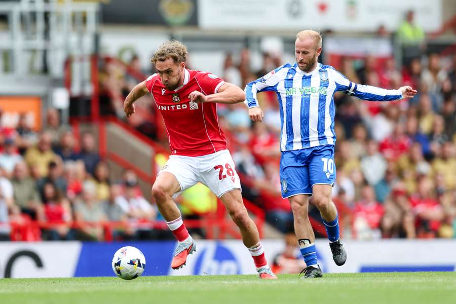 Sam Smith of Wrexham runs with the ball whilst under pressure from Barry Bannan of Sheffield Wednesday