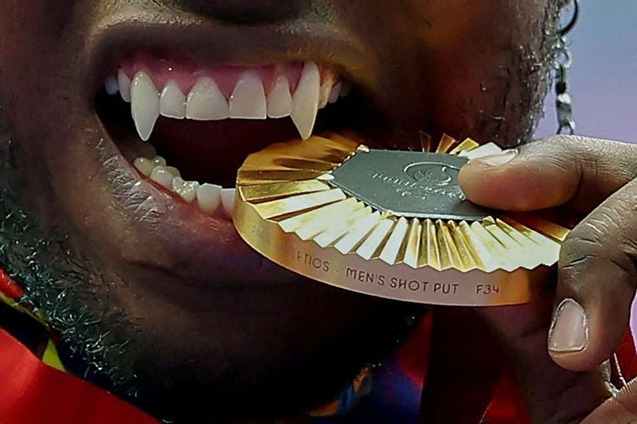 Gold medallist Mauricio Valencia of Colombia bites his medal on the podium