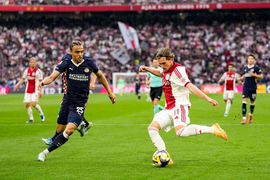 Ajax's Mika Godts (R) crosses a ball during the Eredivisie game against PSV