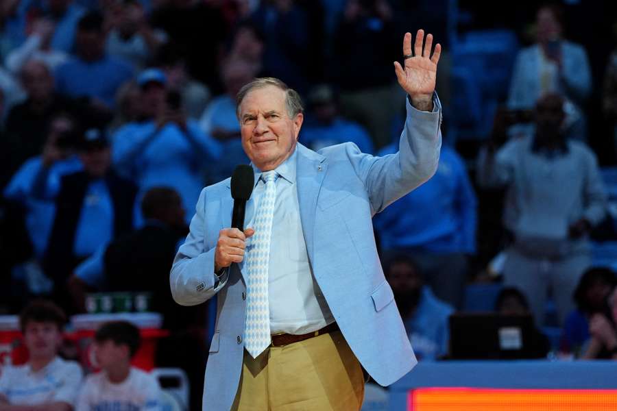 UNC head coach Bill Belichick waves to the students during halftime at a basketball game (2024)