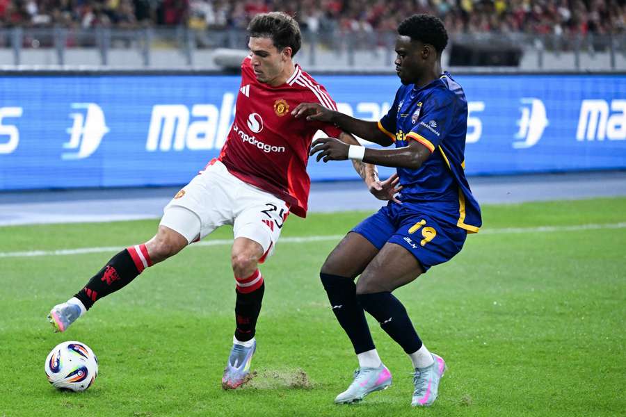 Manchester United's Manuel Ugarte (left) fights for the ball in the exhibition friendly match against ASEAN All-Stars