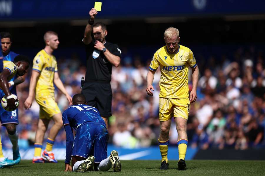 Crystal Palace midfielder Will Hughes is shown a yellow card by referee Jarred Gillett against Chelsea