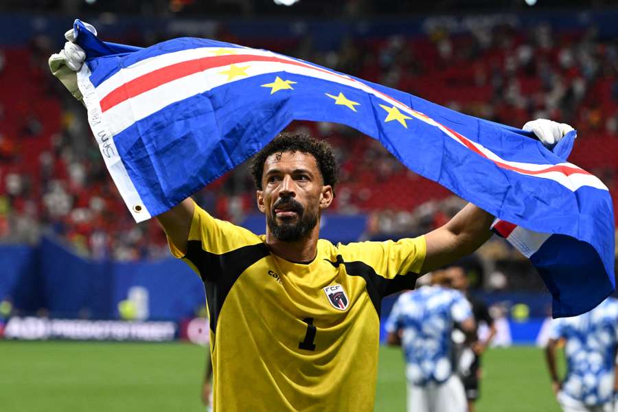 Cape Verde goalkeeper Vozinha proudly holds the national flag after their World Cup draw against Spain. Cape Verde goalkeeper Vozinha proudly holds the national flag after their World Cup draw against Spain.