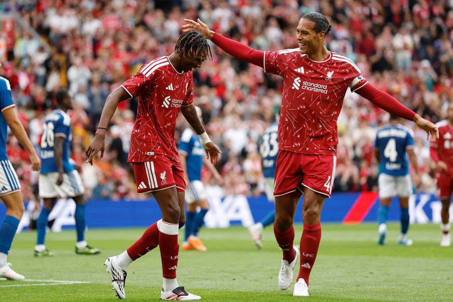 Jacquet celebrates with Liverpool captain Van Dijk at Anfield