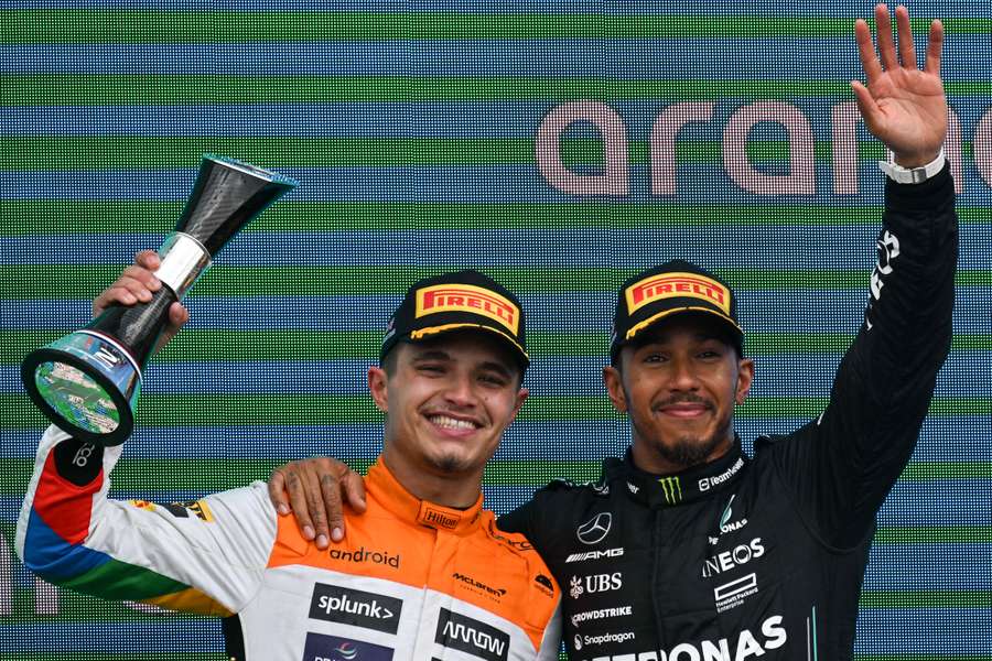 Lando Norris ao lado de Lewis Hamilton no pódio em Silverstone