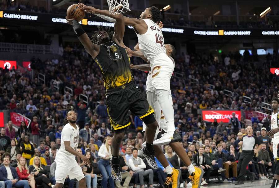 Donovan Mitchell doet er alles aan een schot van Kevon Looney te blocken