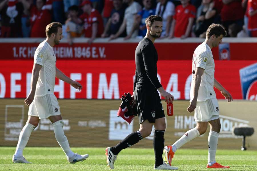 Bayern Munich's English forward #09 Harry Kane (L), goalkeeper #26 Sven Ulreich (C) and forward #25 Thomas Mueller leave the pitch 