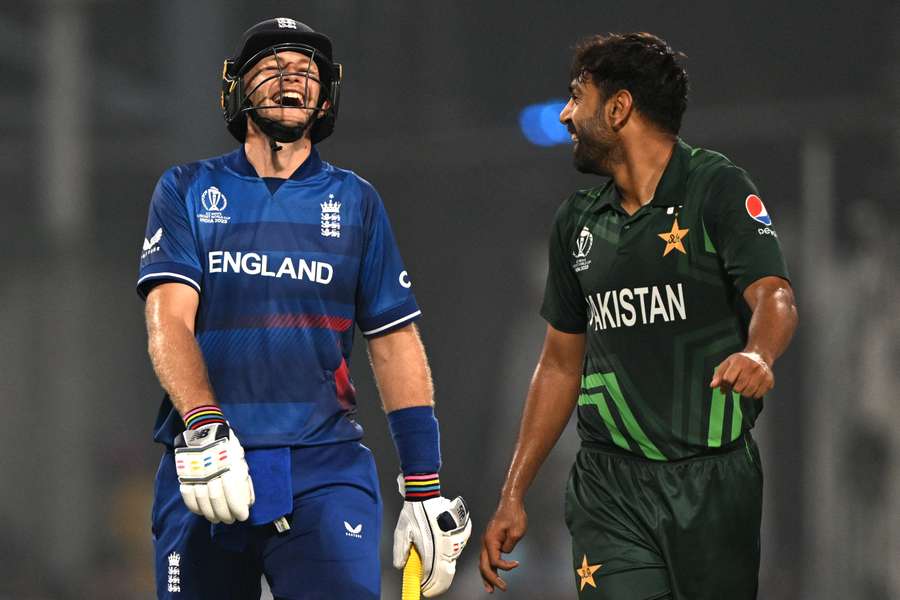 Pakistan's Haris Rauf (R) speaks with England's Joe Root