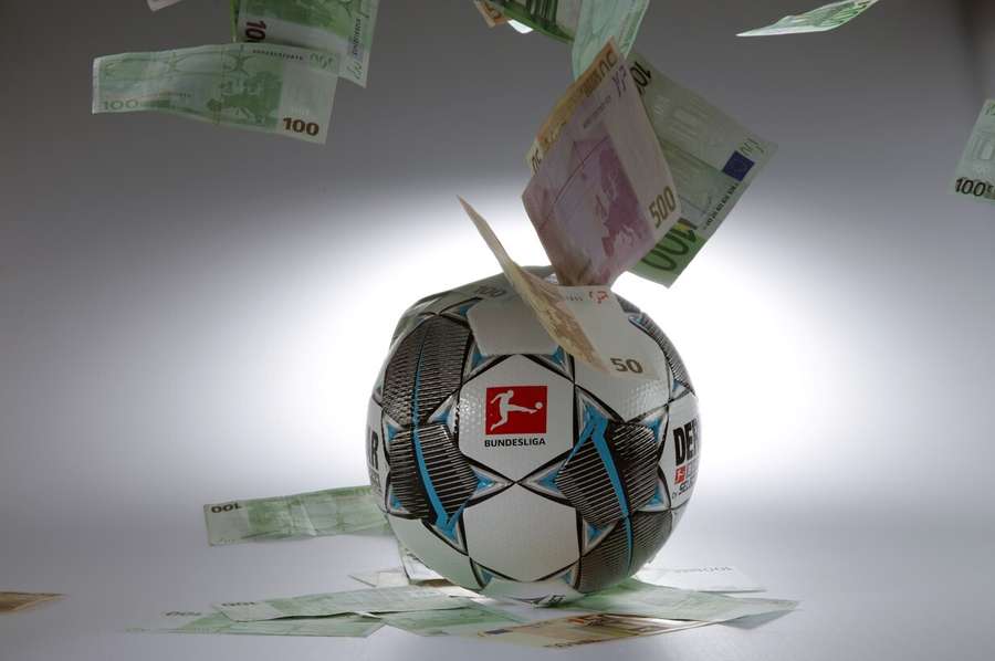 Symbolbild: Der offizielle Bundesliga-Spielball, von Geldscheinen umweht