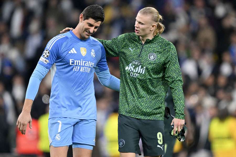 Real Madrid's Thibaut Courtois (L) with Manchester City's Erling Haaland