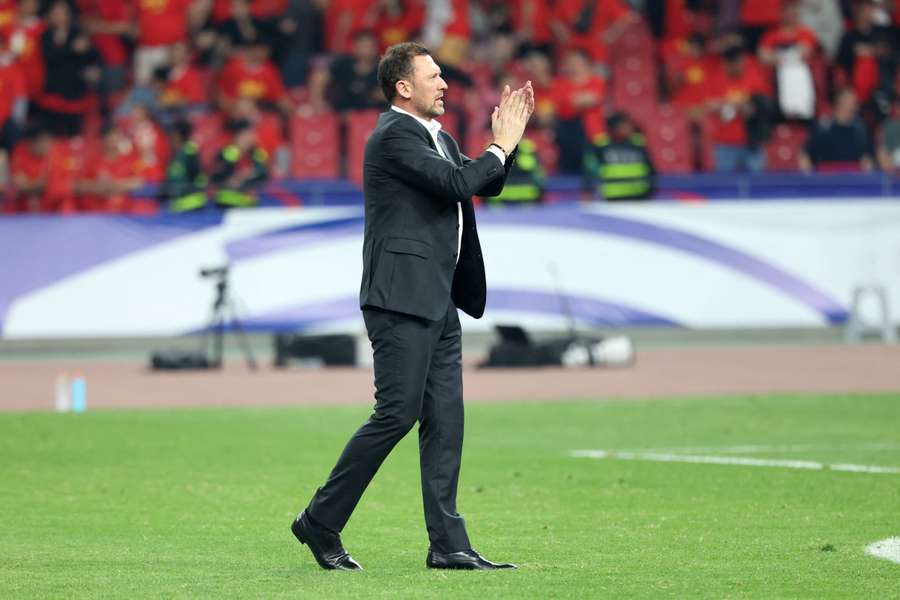 Australia manager Tony Popovic applauds travelling fans after their 2-0 FIFA World Cup qualification win in China.