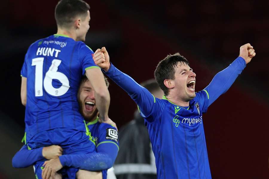 Grimsby players celebrate after winning their English FA Cup fifth round match