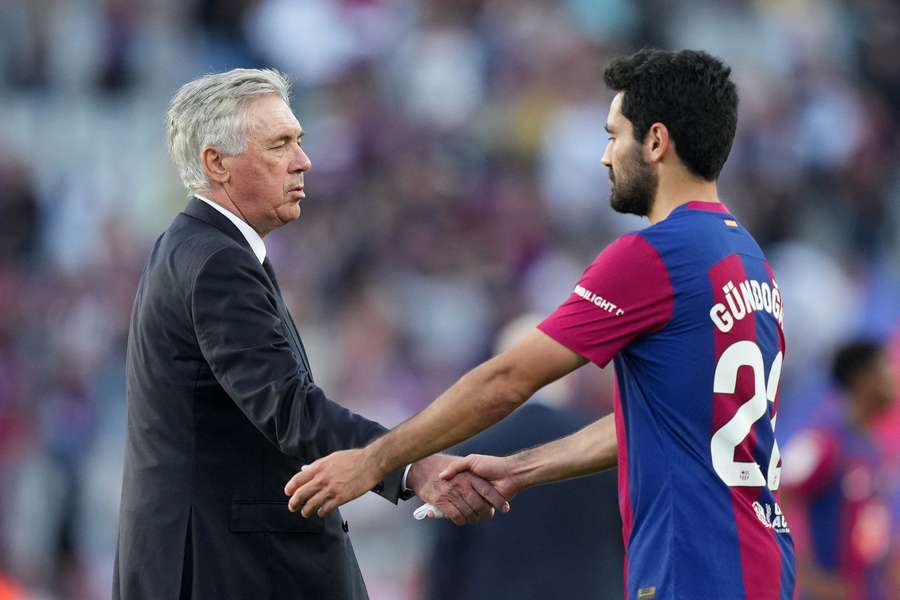 Carlo Ancelotti, Head Coach of Real Madrid, shakes hands with Ilkay Guendogan of FC Barcelona