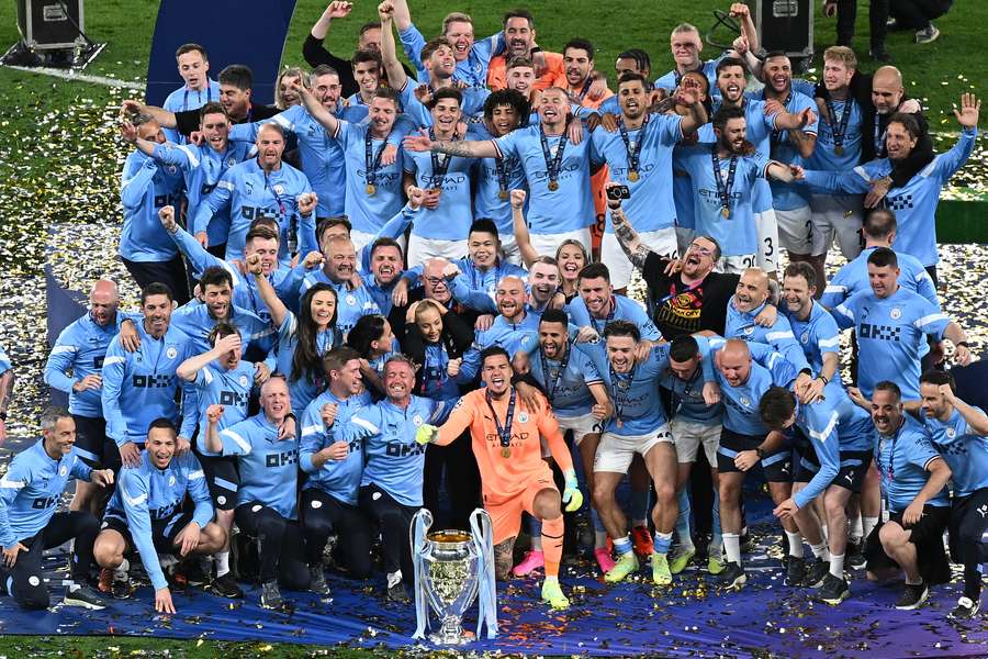 City players and staff pose with the Champions League trophy