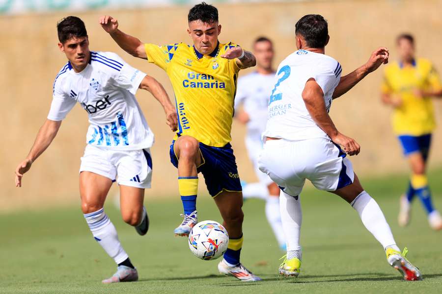 Alberto Moleiro intenta zafarse de dos jugadores del Como