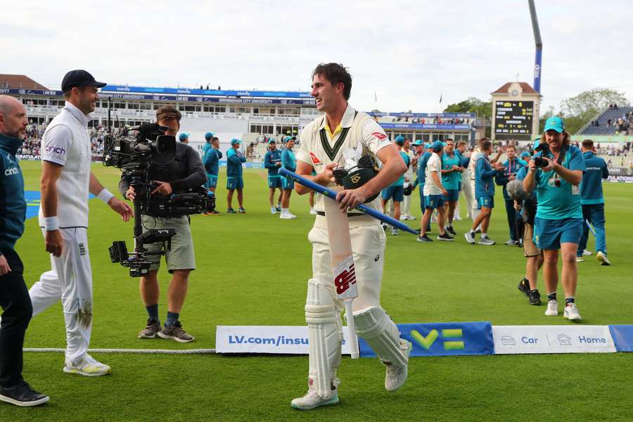 England's James Anderson (2L) reacts as Australia's Pat Cummins (C) leaves the pitch at the end of play on day five