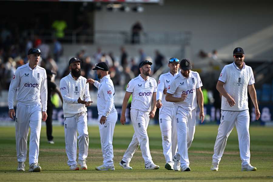 England's Mark Wood, centre, and teammates leave the field at the end of play on day two