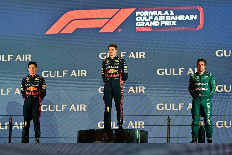 Red Bull's Dutch driver Max Verstappen (C), Red Bull's Mexican driver Sergio Perez (L) and Aston Martin's Spanish driver Fernando Alonso (R) attend the podium ceremony