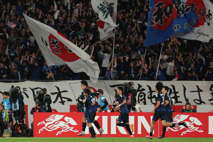Japan's players celebrate their third goal against Brazil
